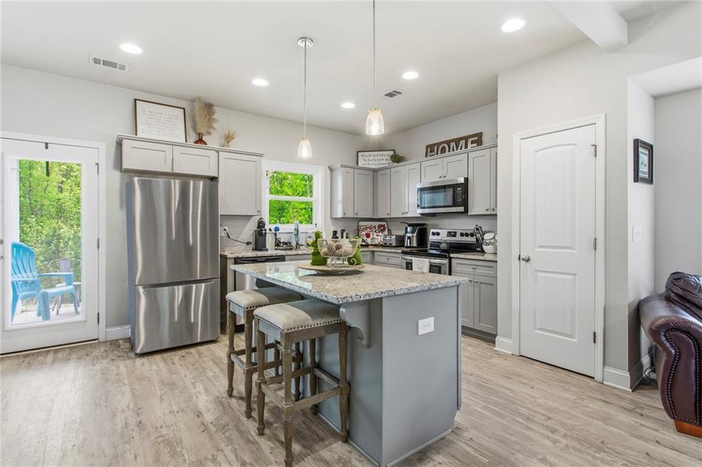 171 Strickland Loop Forsyth, GA 31029 - Photo 5 of 25 a kitchen with kitchen island a refrigerator stove and microwave