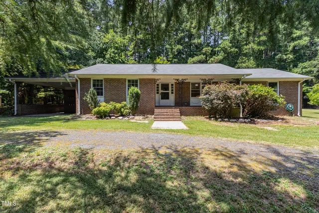a view of a house with yard and sitting area