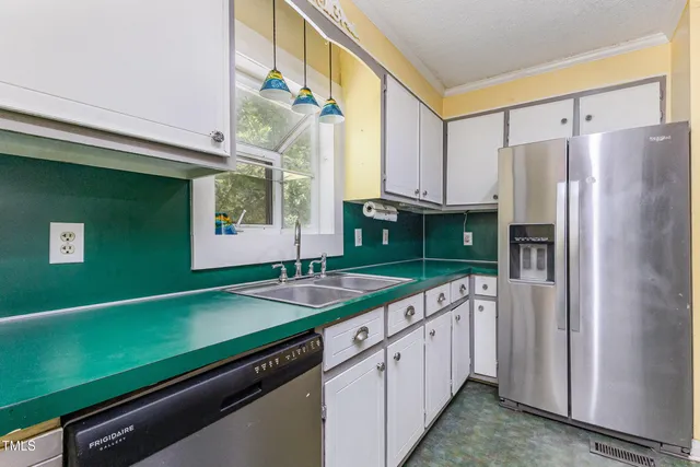 a kitchen with kitchen island a sink cabinets and refrigerator