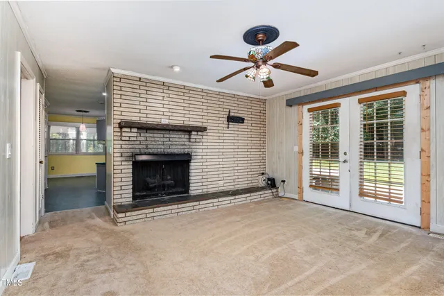 a view of a livingroom with a fireplace and window