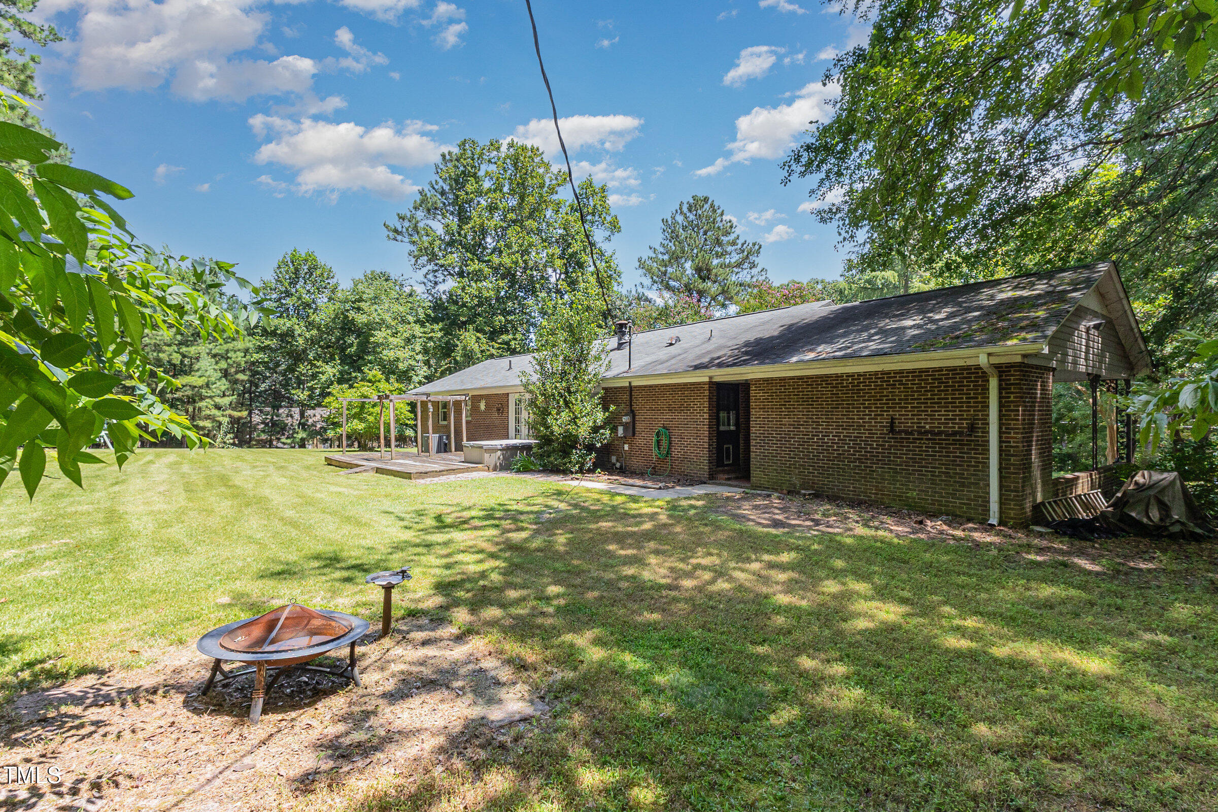 817 Bent Creek Road Bahama, NC 27503 - Photo 30 of 45 a backyard of a house with table and chairs under an umbrella