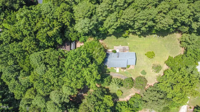 an aerial view of a house with a yard and large tree
