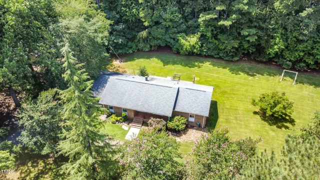 an aerial view of a house with swimming pool and garden