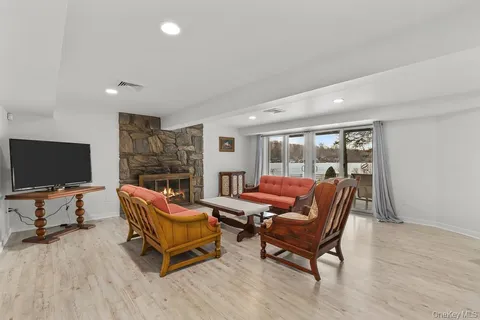 a living room with furniture a flat screen tv and a large window