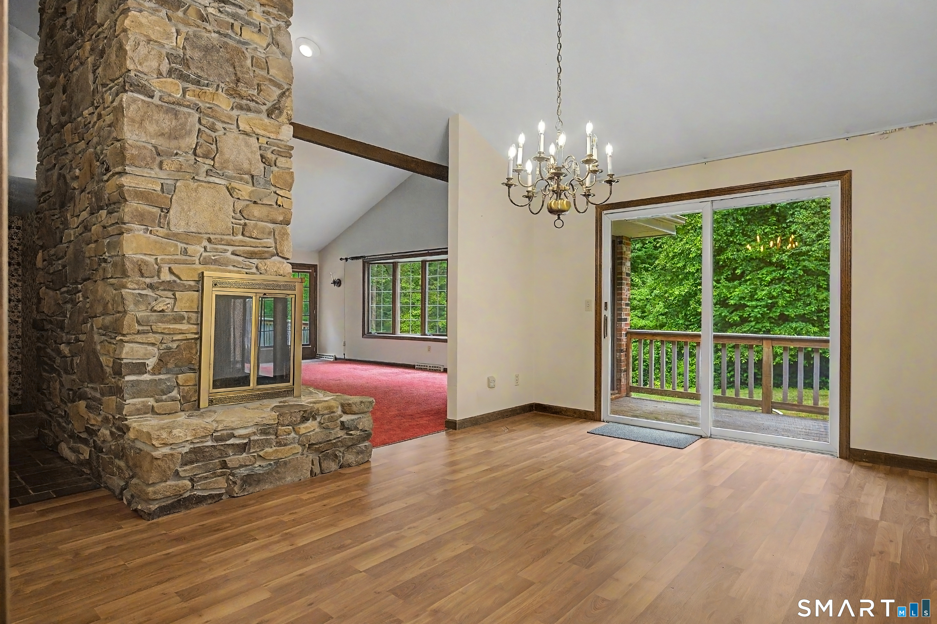 370 Hubbard Road Haddam, CT 06441 - Photo 16 of 39 Dinning room with cathedral ceilings, two sided wood burning fireplace, sliders to rear deck with composite decking.