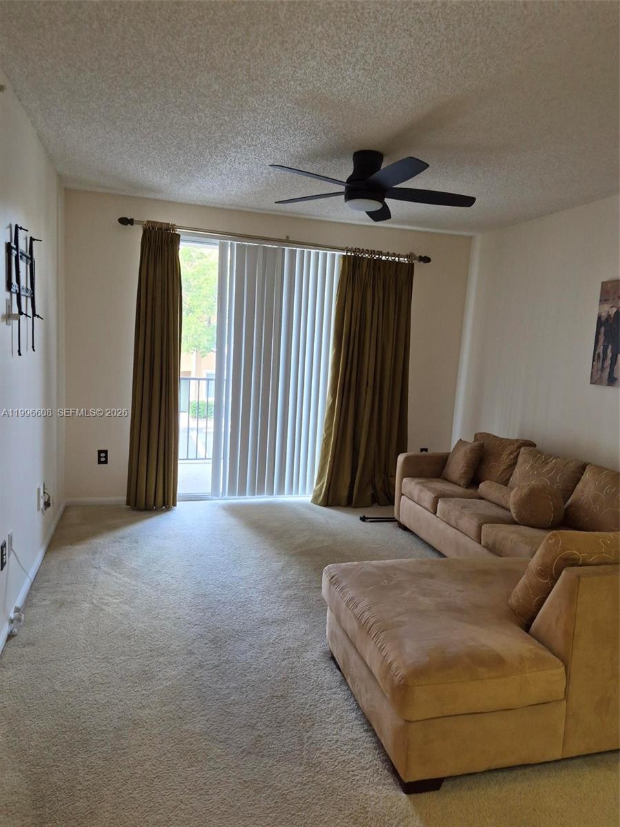 8050 North Nob Hill Road, Unit 203 Tamarac, FL 33321 - Photo 2 of 9 a living room with furniture and a window