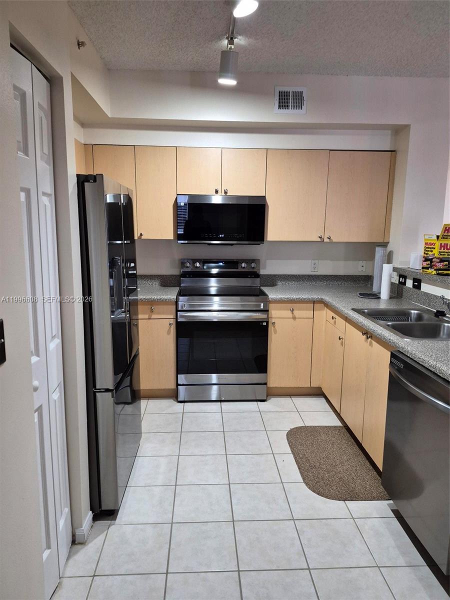 8050 North Nob Hill Road, Unit 203 Tamarac, FL 33321 - Photo 8 of 9 a kitchen with a stove sink and refrigerator