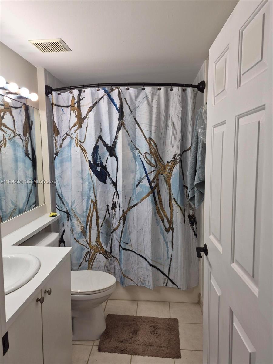 8050 North Nob Hill Road, Unit 203 Tamarac, FL 33321 - Photo 9 of 9 a bathroom with a toilet sink and mirror