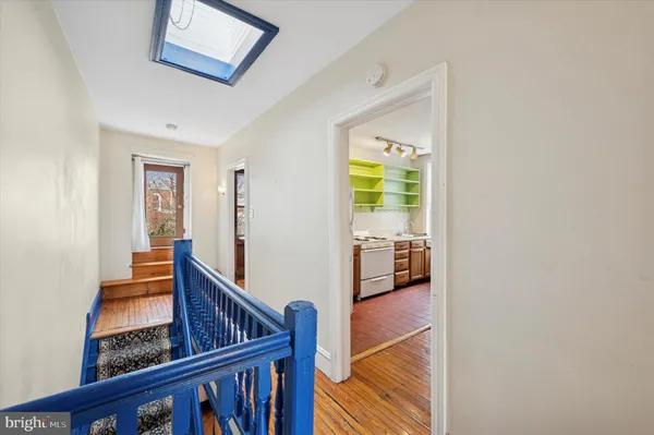 a view of a hallway with wooden floor and windows