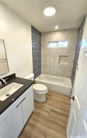 a bathroom with a granite countertop sink toilet a mirror and shower
