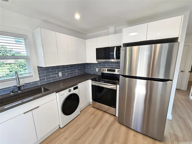 a kitchen with stainless steel appliances a refrigerator sink and microwave