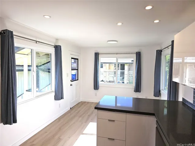 a kitchen with granite countertop sink stove and refrigerator