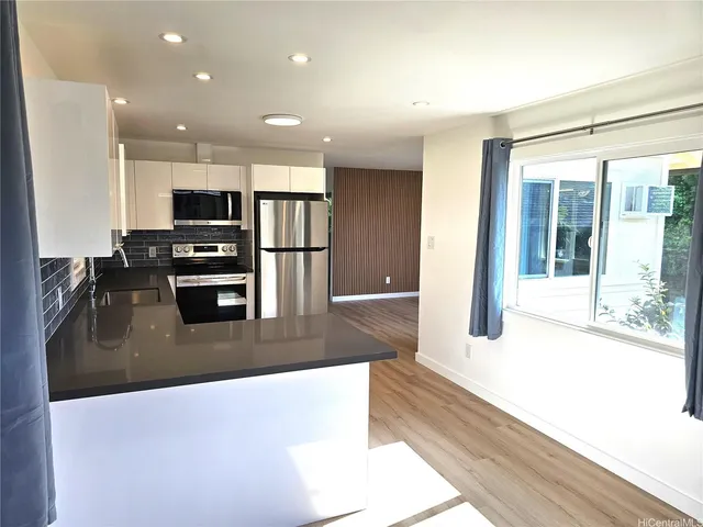 a kitchen with stainless steel appliances granite countertop a refrigerator and a sink