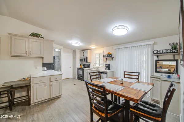 a kitchen with a dining table chairs and refrigerator