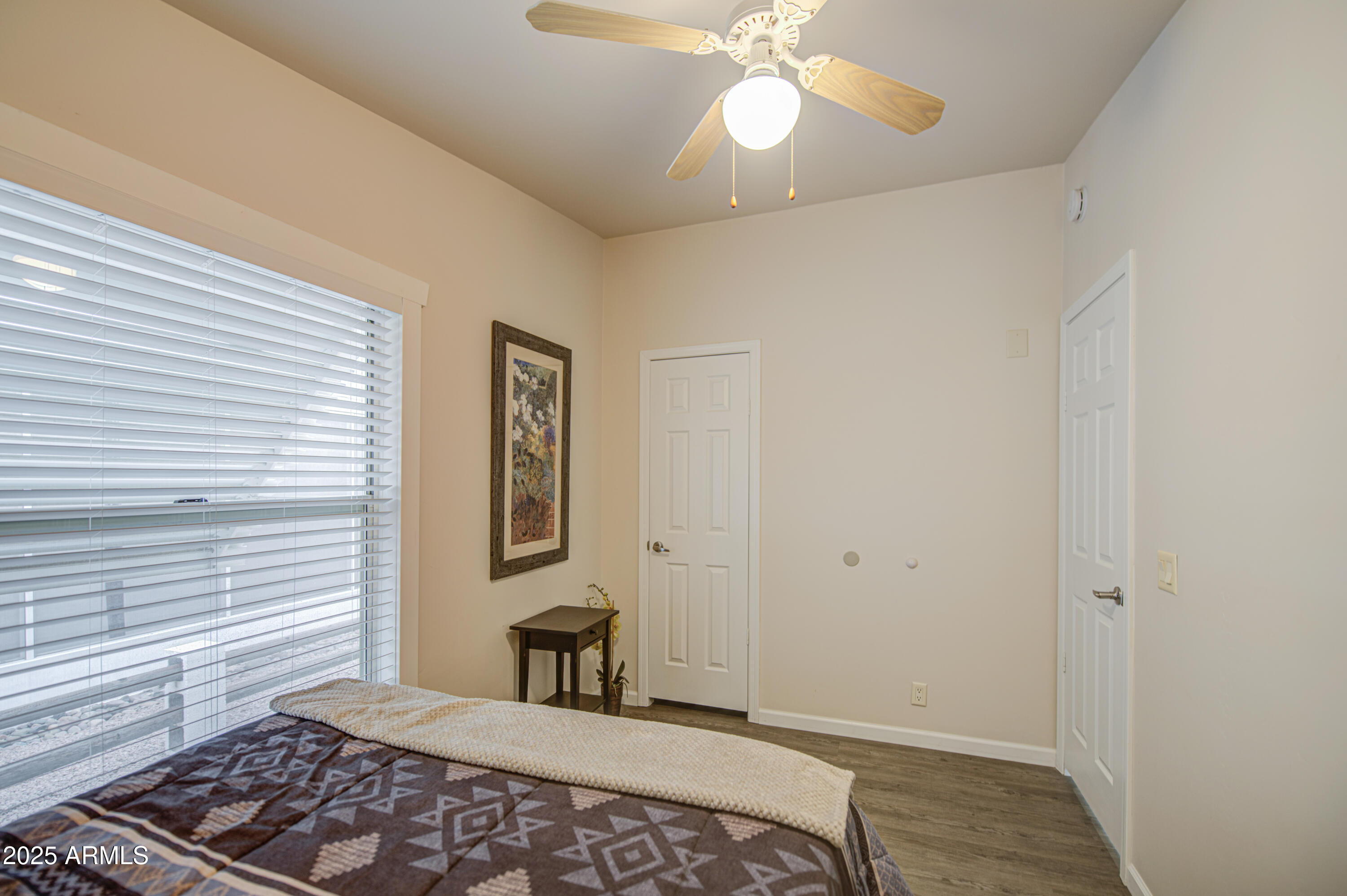 2208 West Baseline Avenue, Unit 67 Apache Junction, AZ 85120 - Photo 34 of 41 a bedroom with a bed and wooden floor