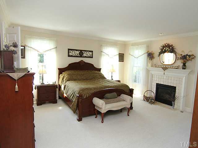 511 Mason Road Durham, NC 27712 - Photo 9 of 25 a bedroom with a bed and a fireplace