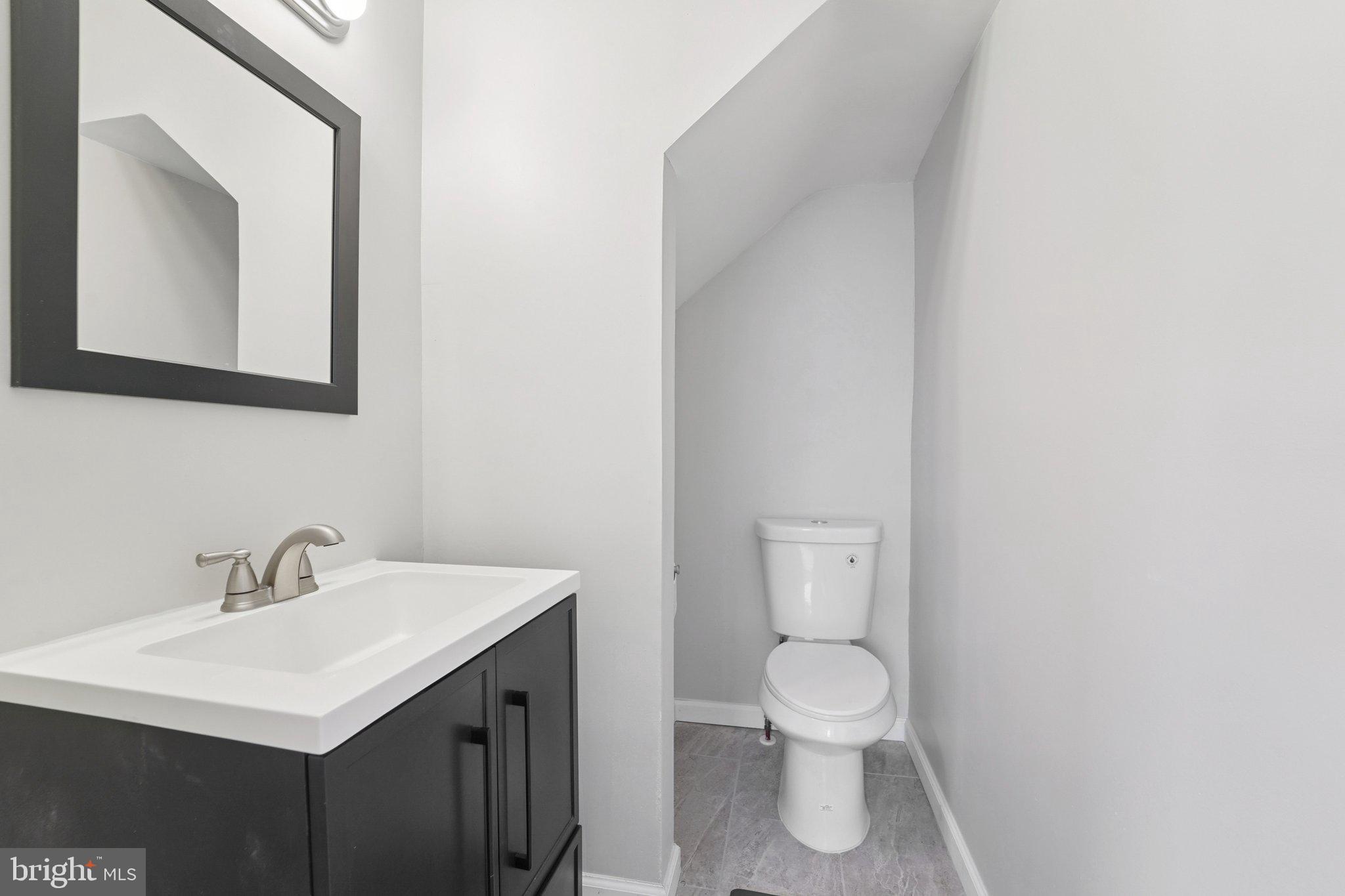 5701 The Alameda Baltimore, MD 21239 - Photo 11 of 29 a bathroom with a toilet sink and mirror