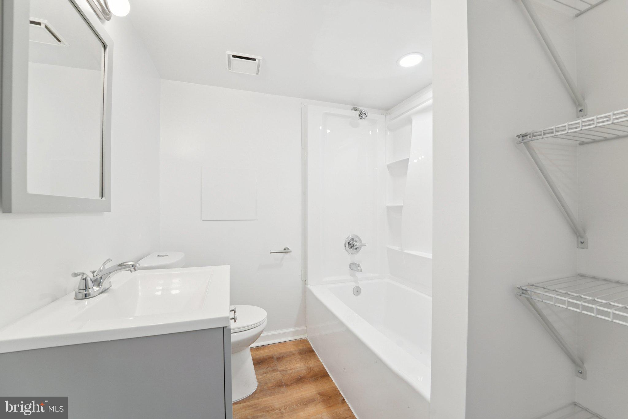 5701 The Alameda Baltimore, MD 21239 - Photo 27 of 29 a bathroom with a bathtub a sink a toilet and a mirror