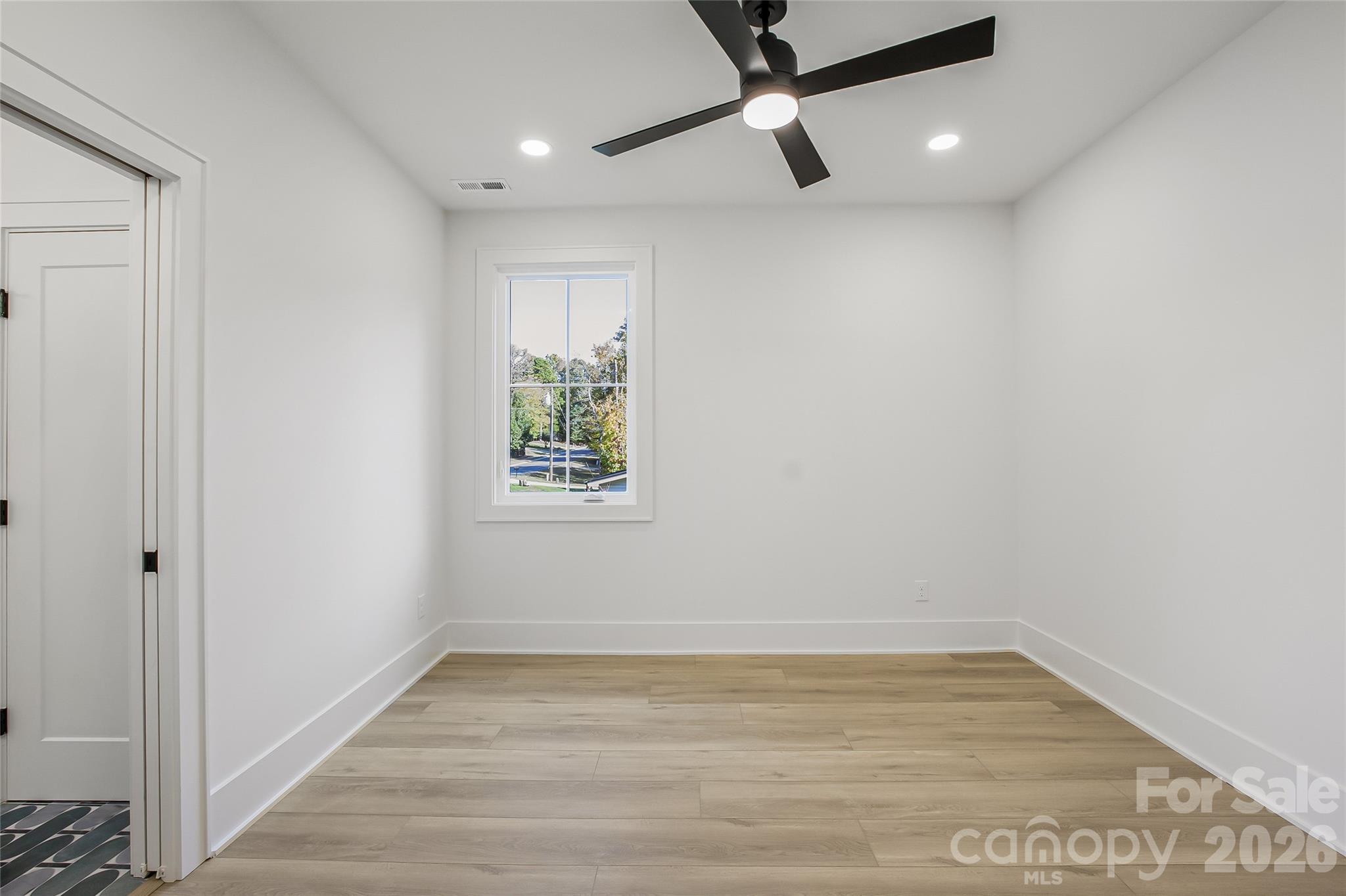 4221 Spring Street Charlotte, NC 28270 - Photo 31 of 44 an empty room with wooden floor fan and windows