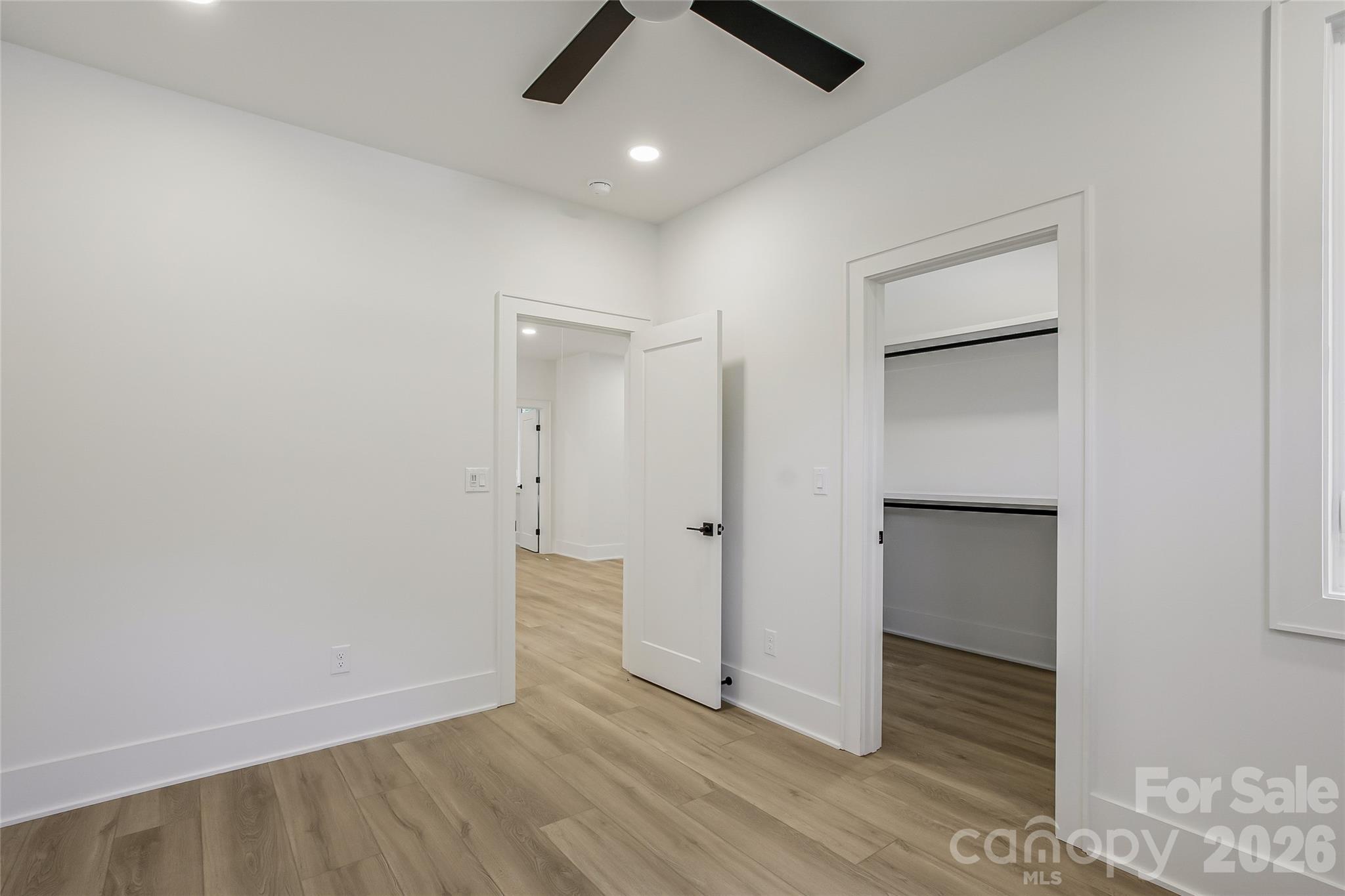 4221 Spring Street Charlotte, NC 28270 - Photo 34 of 44 an empty room with wooden floor and ceiling fan