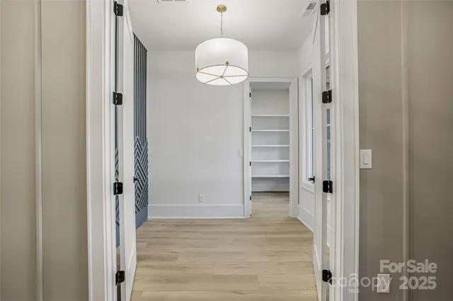 a view of a hallway with wooden floor