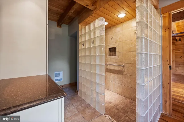 a spacious bathroom with a double vanity sink a mirror and a shower