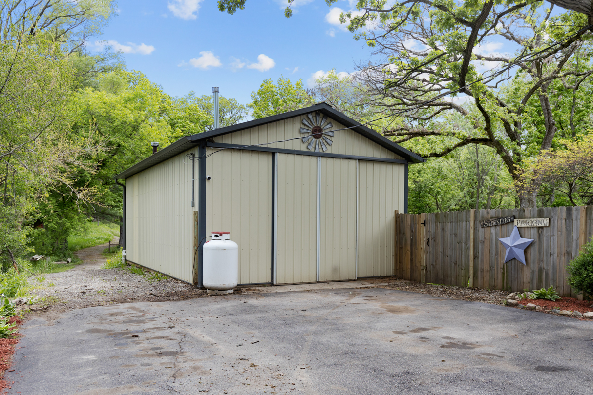4604 Sunnyside Road Woodstock, IL 60098 - Photo 33 of 37 a wooden house with a large tree and wooden fence