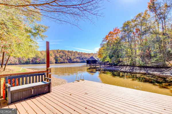 a view of a rooftop deck with lake and trees in the background