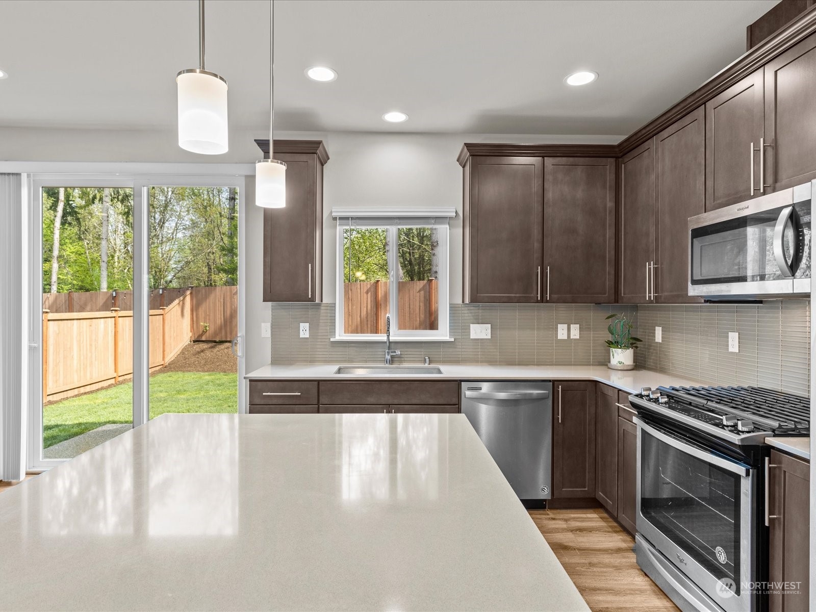20713 42nd Avenue Southeast, Unit A Bothell, WA 98021 - Photo 16 of 32 a kitchen with stainless steel appliances granite countertop a sink a stove and a wooden cabinets