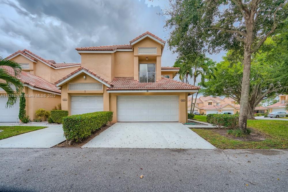23060 Aqua, Unit 8 Boca Raton, FL 33433 - Photo 1 of 33 a front view of a house with garden
