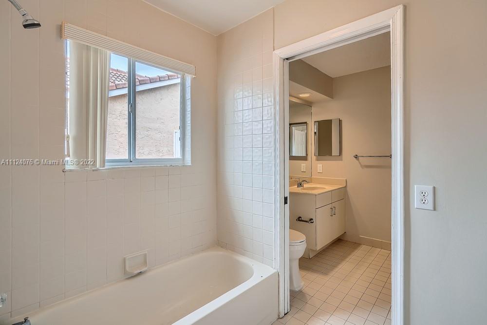 23060 Aqua, Unit 8 Boca Raton, FL 33433 - Photo 12 of 33 a bathroom with a granite countertop sink a toilet and shower