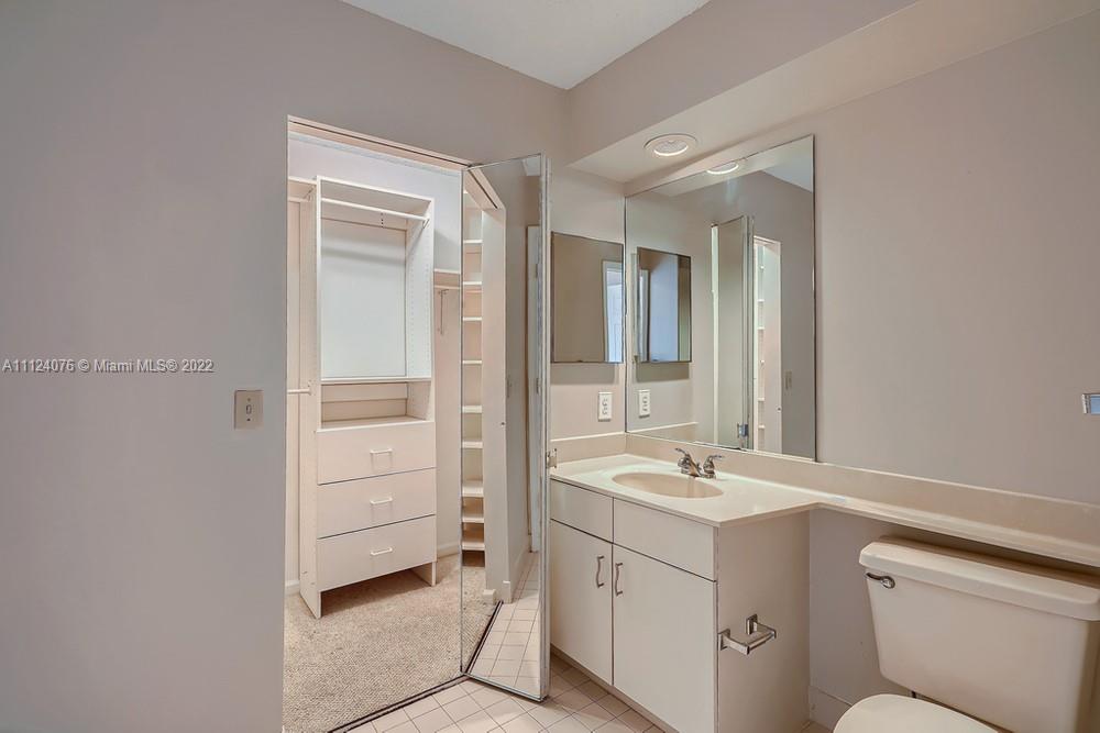 23060 Aqua, Unit 8 Boca Raton, FL 33433 - Photo 13 of 33 a bathroom with a sink a toilet and shower