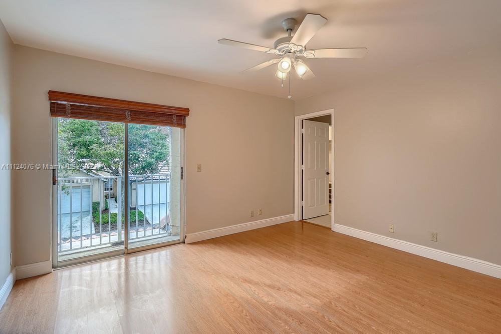 23060 Aqua, Unit 8 Boca Raton, FL 33433 - Photo 15 of 33 an empty room with wooden floor and windows