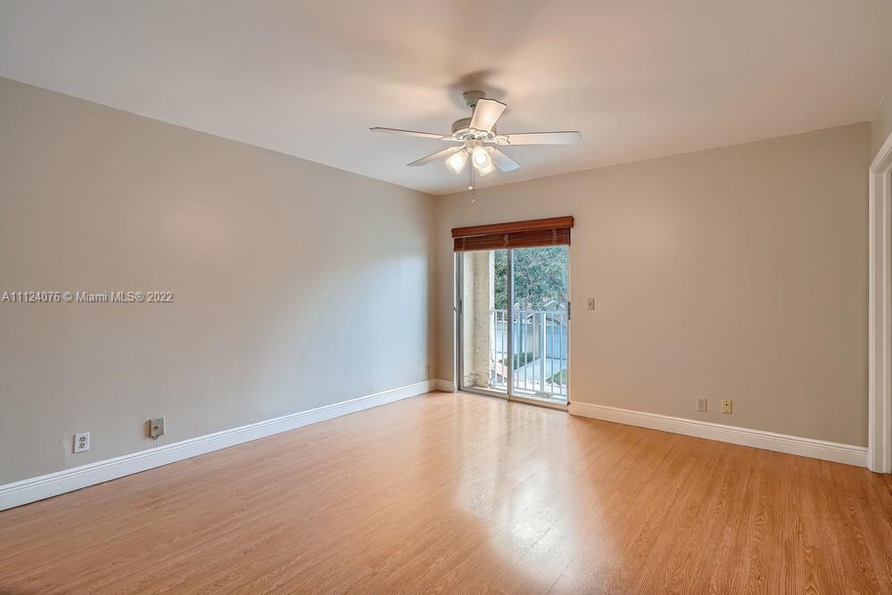 23060 Aqua, Unit 8 Boca Raton, FL 33433 - Photo 16 of 33 an empty room with wooden floor fan and windows