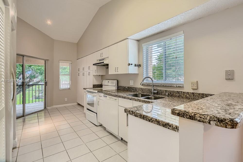 23060 Aqua, Unit 8 Boca Raton, FL 33433 - Photo 20 of 33 a kitchen with stainless steel appliances granite countertop a stove a sink and a microwave