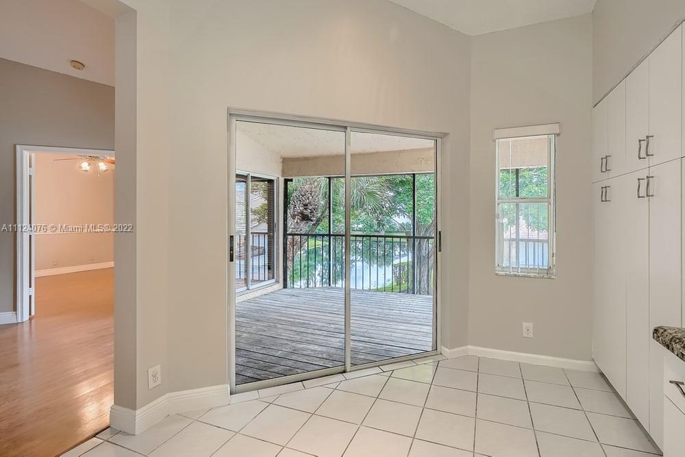 23060 Aqua, Unit 8 Boca Raton, FL 33433 - Photo 23 of 33 a view of an empty room with wooden floor and a window