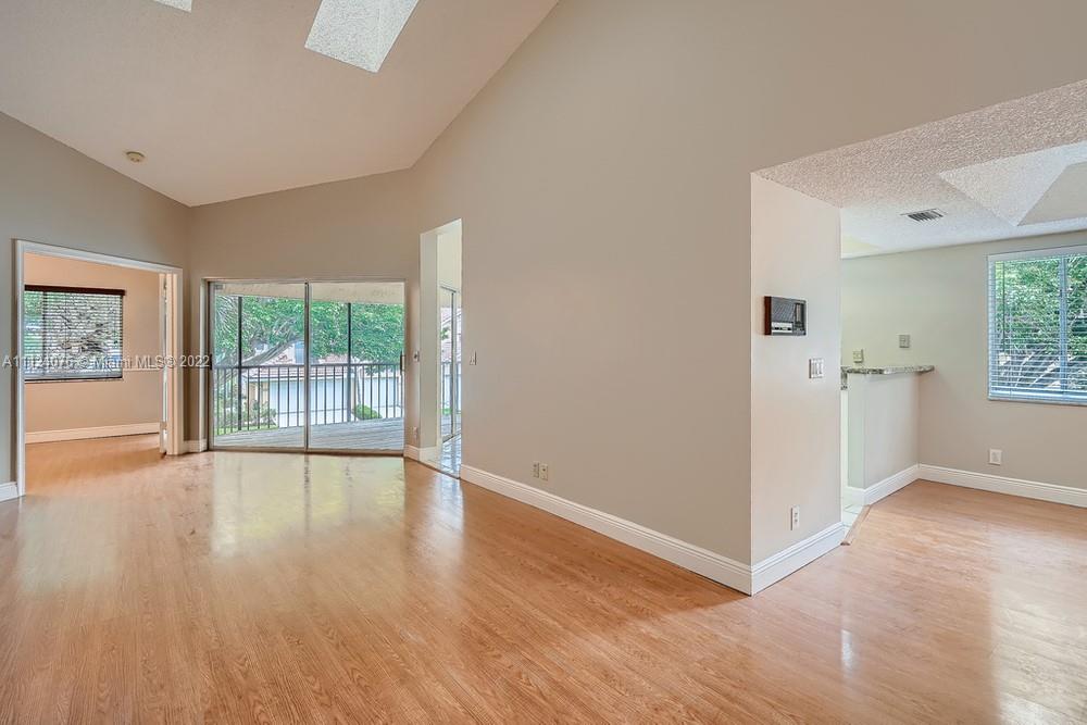 23060 Aqua, Unit 8 Boca Raton, FL 33433 - Photo 25 of 33 an empty room with wooden floor and windows