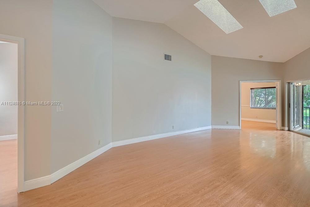 23060 Aqua, Unit 8 Boca Raton, FL 33433 - Photo 26 of 33 a view of an empty room with window and wooden floor
