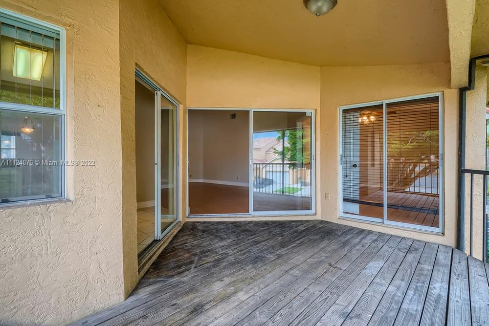 23060 Aqua, Unit 8 Boca Raton, FL 33433 - Photo 30 of 33 an empty room with wooden floor and windows