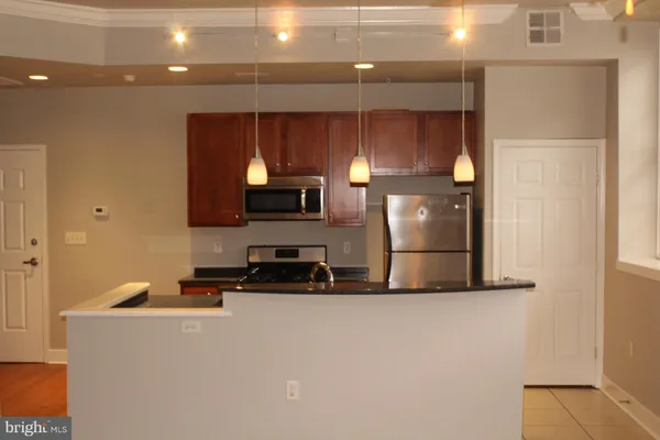 a kitchen with stainless steel appliances a refrigerator and microwave