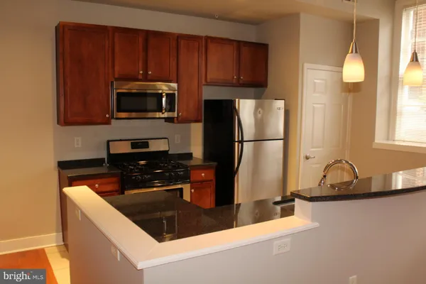 a kitchen with a sink a microwave a refrigerator and cabinets