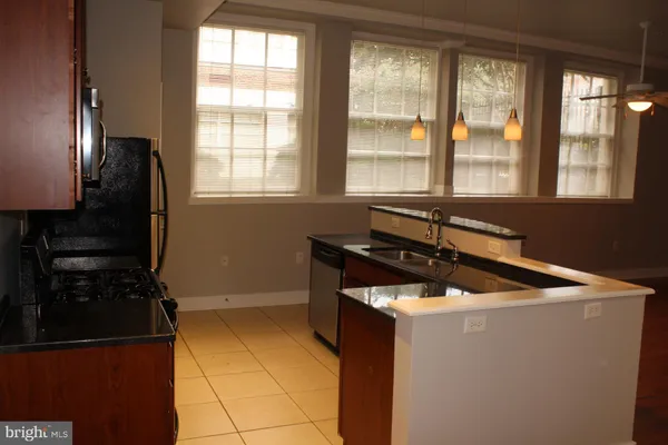 a close view of sink and dishwasher with kitchen island