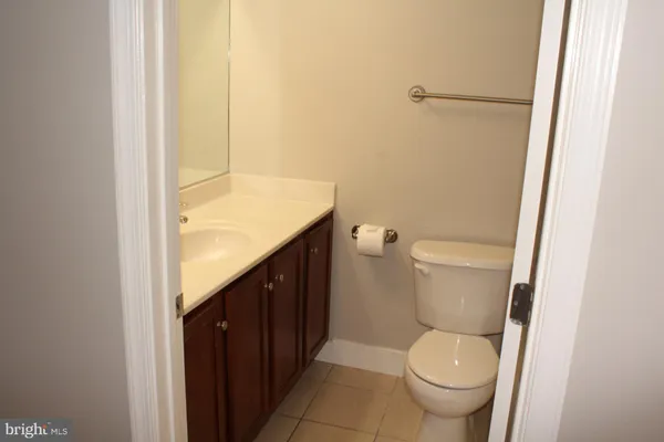a bathroom with a granite countertop toilet and a sink