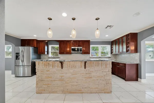 a large kitchen with stainless steel appliances granite countertop a refrigerator a oven and a sink