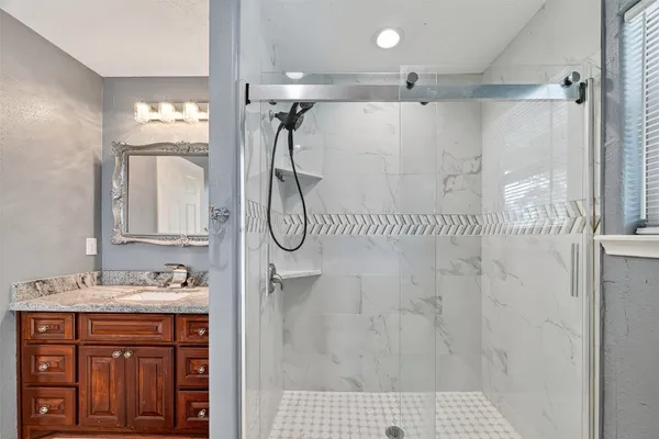 a bathroom with a shower sink and mirror
