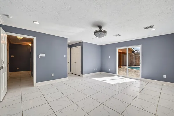 a view of an empty room with window and cabinet