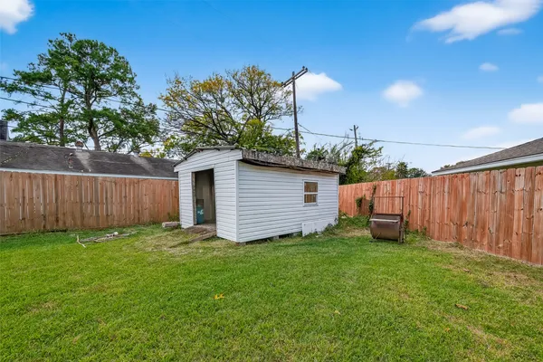 a view of a backyard with potted plants and wooden fence