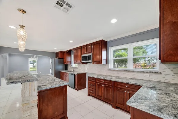 a kitchen with stainless steel appliances granite countertop a stove sink and cabinets