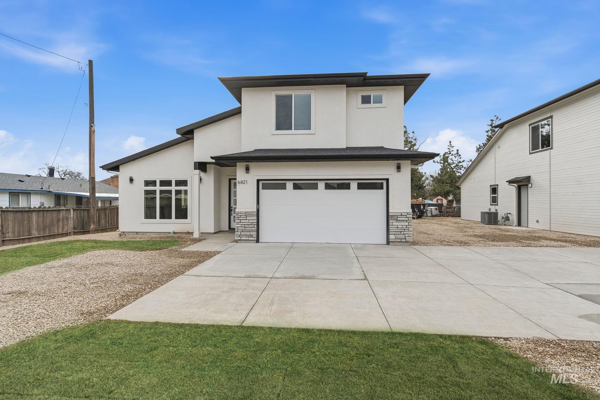 View of front of property with a garage, stucco siding, concrete driveway, and stone siding