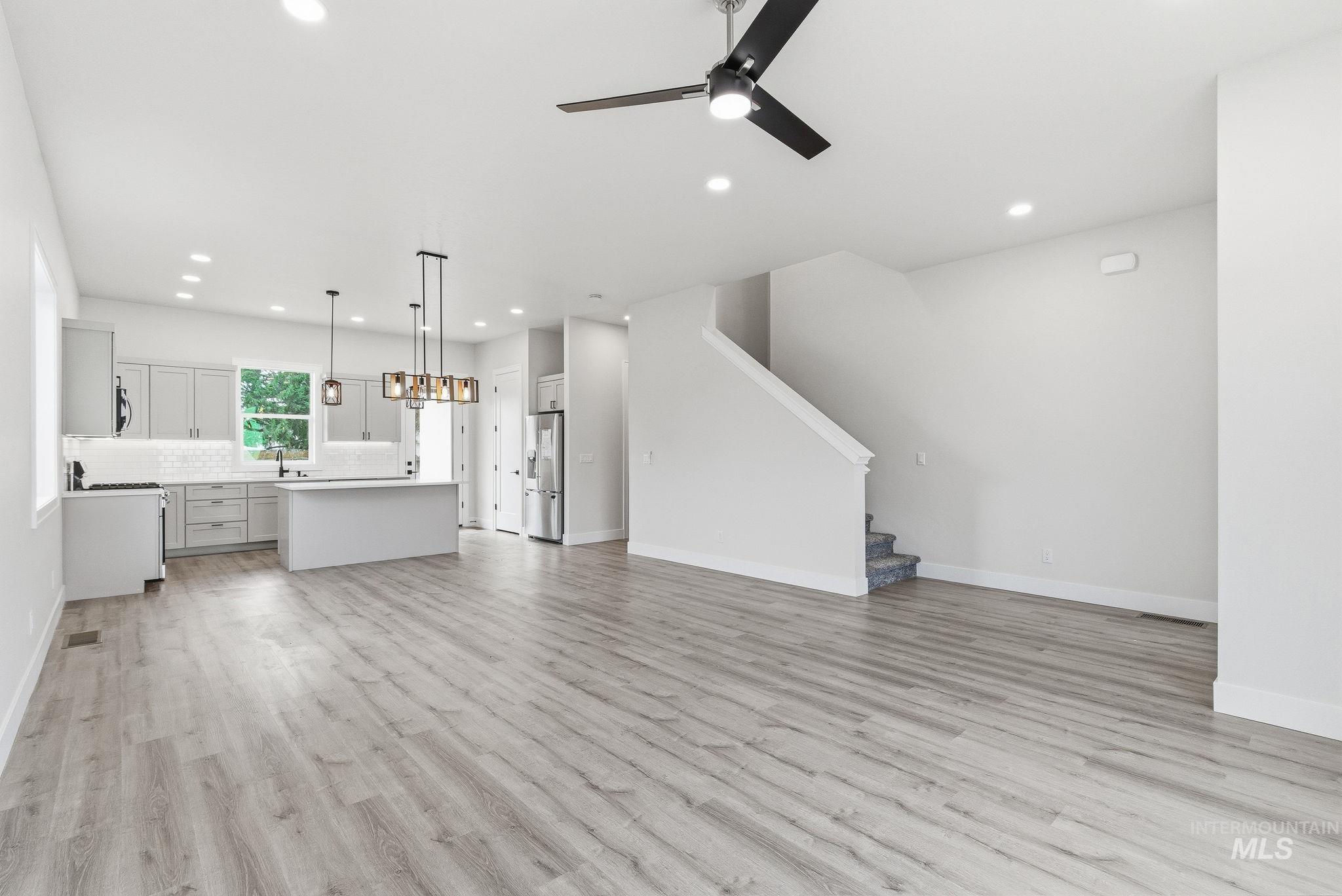 6821 West Ustick Road Boise, ID 83704 - Photo 21 of 42 Unfurnished living room featuring a ceiling fan, recessed lighting, and light wood-style flooring